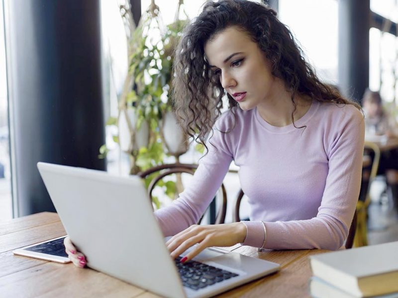 young-woman-working-on-laptop-in-coffee-shop-K9HY7LD-1.jpg